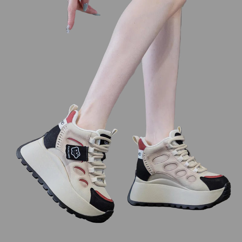 White genuine leather sneakers with black and red accents worn by a person on a gray floor.
